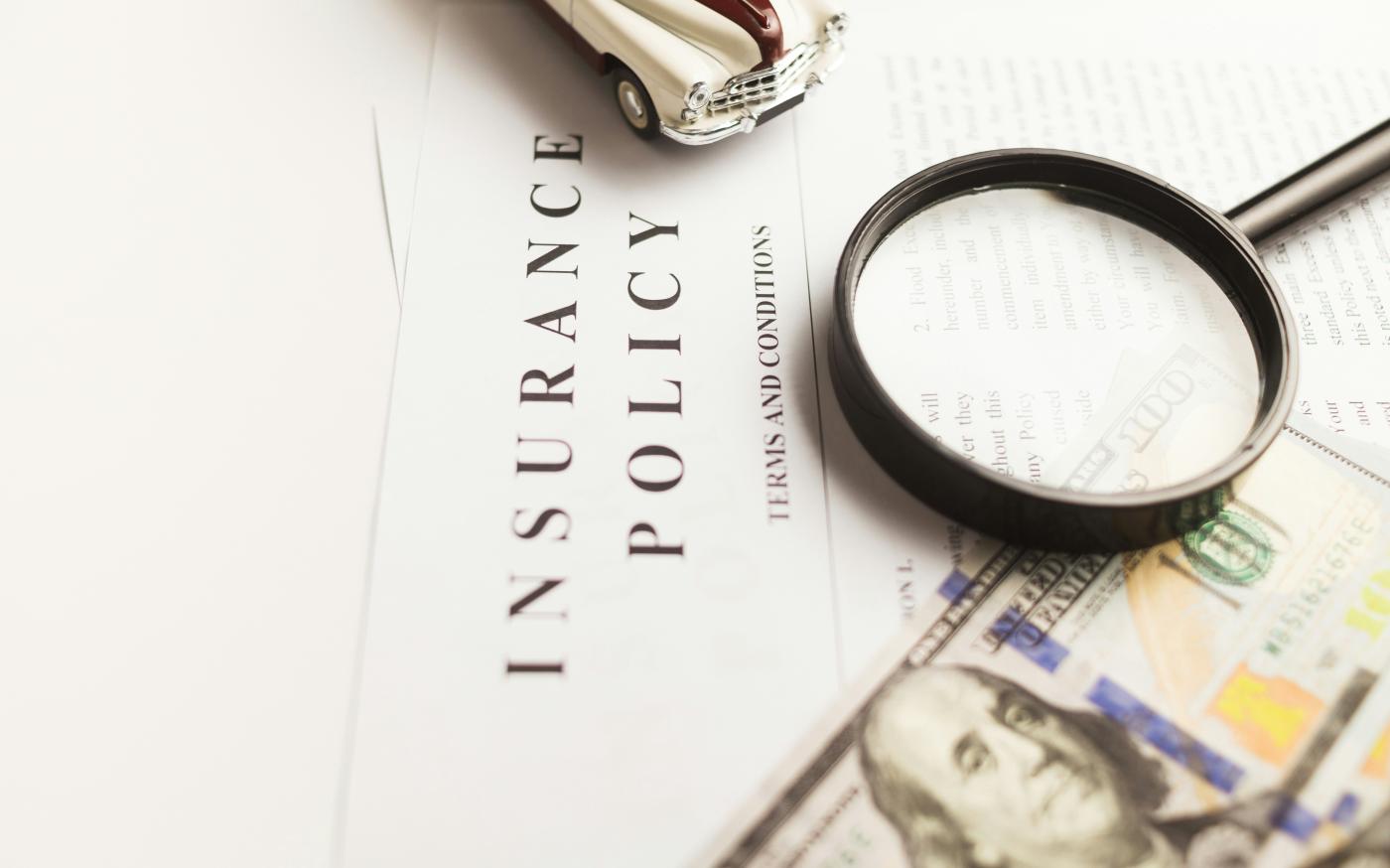 a magnifying glass sitting on top of an insurance policy by Vlad Deep courtesy of Unsplash.